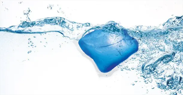 blue water-soluble pod dissolving in clear water, surrounded by bubbles and ripples, illustrating the concept of water solubility