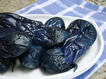 ichiban japanese eggplants on a white plate, showcasing their dark purple skin and slender shape, often used in asian cuisine