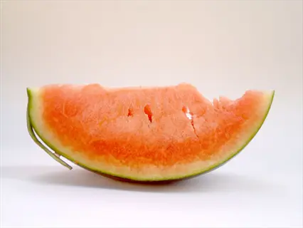 orange flesh watermelon slice with a bite taken out, on a white background
