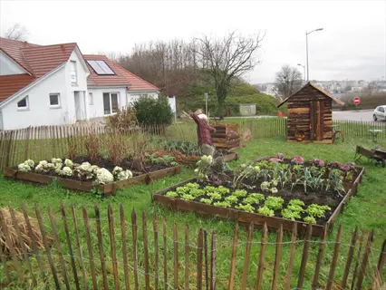 potager kitchen garden with raised beds and a wooden fence