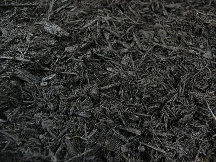 winter garden mulch: close-up of dark organic wood chips and compost blend for plant protection