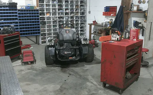 workshop with xmark lawn mower and lawn mower maintenance tools for winterizing lawn equipment